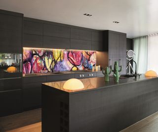 brightly coloured glass splashback in kitchen with black units