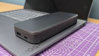 Lenovo Go USB-C laptop power bank sitting on a Yoga Slim 7i laptop to show the size