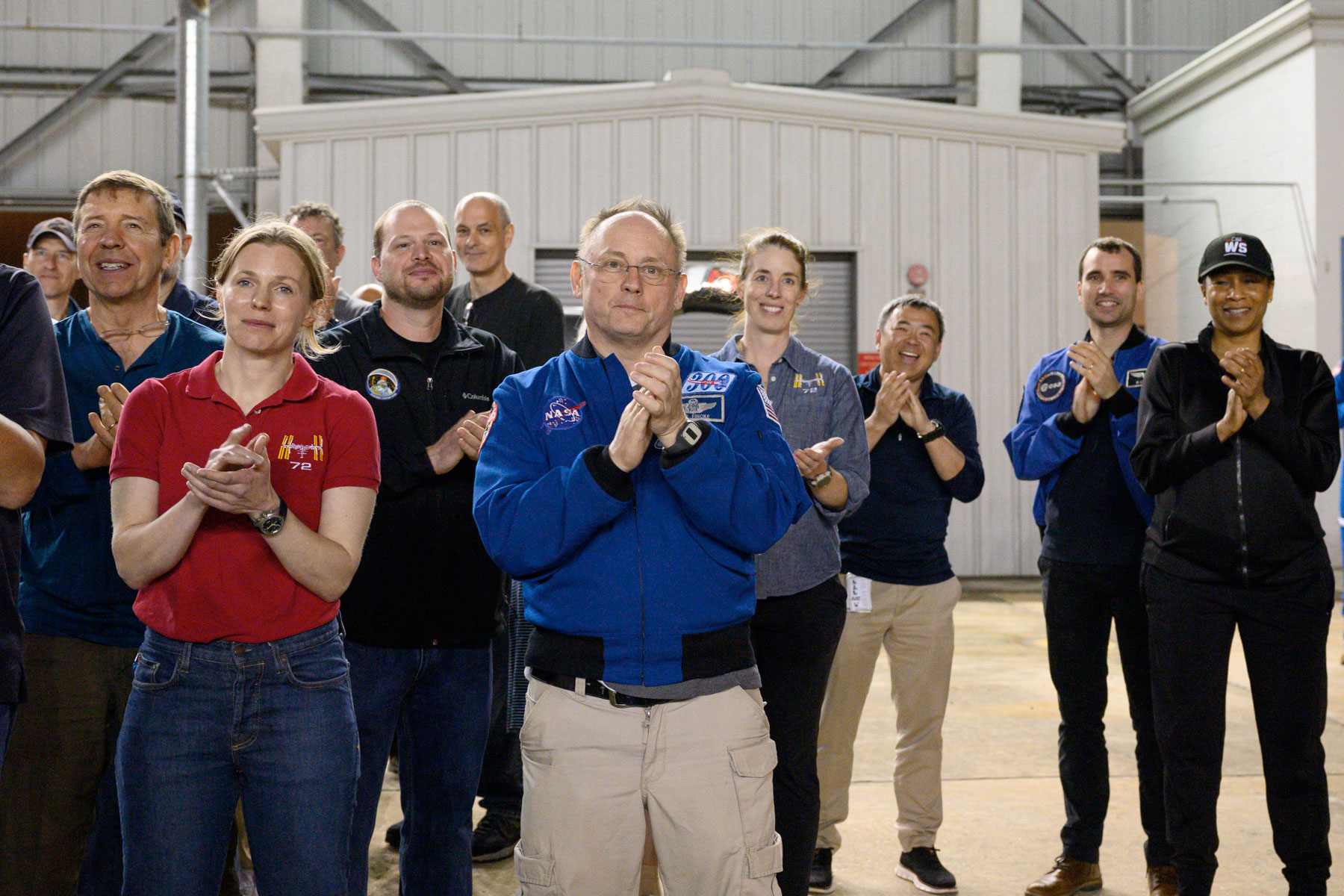 A group of astronauts applaud as they welcome their colleagues (not pictured) home from space