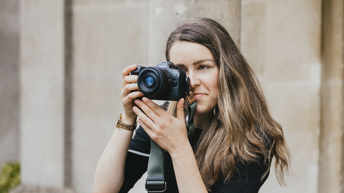 A photographer holding the Canon EOS R6 up to their face