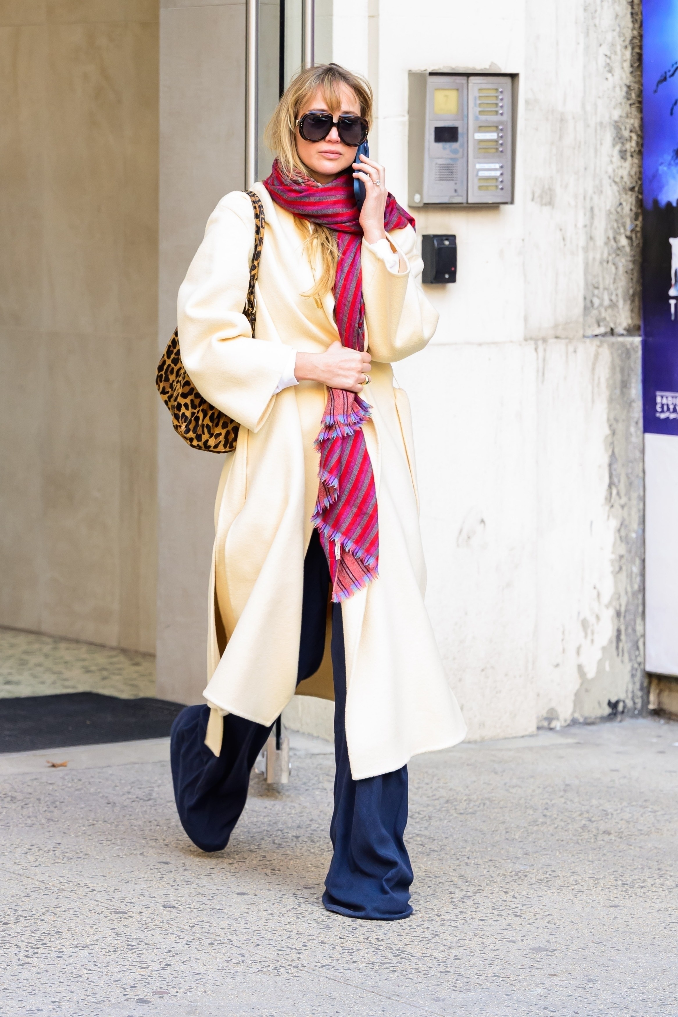 Jennifer Lawrence was spotted in New York City wearing a butter yellow coat, wide-leg trousers, and a leopard-print Prada bag