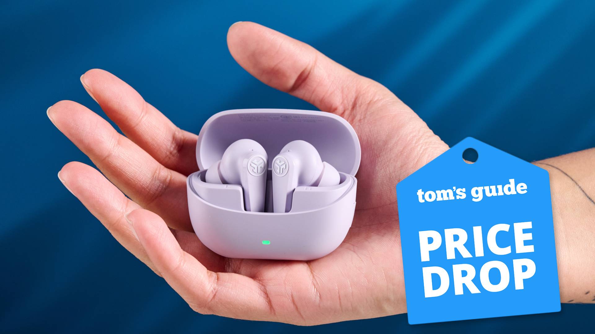 The JLab Go Pods ANC earbuds held in-hand against a blue background