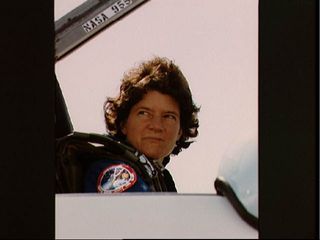 Astronaut Sally Ride is seated in the cockpit of a T-38 aircraft in preparation to depart for the Kennedy Space Center ahead of the STS-41G mission.