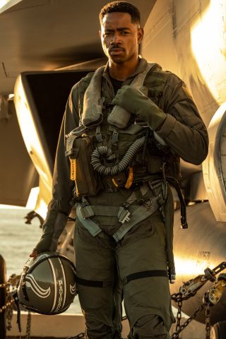 Jay Ellis standing on the fight deck in full flight gear, in Top Gun: Maverick.