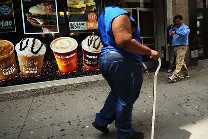 A woman walks past a McDonalds.