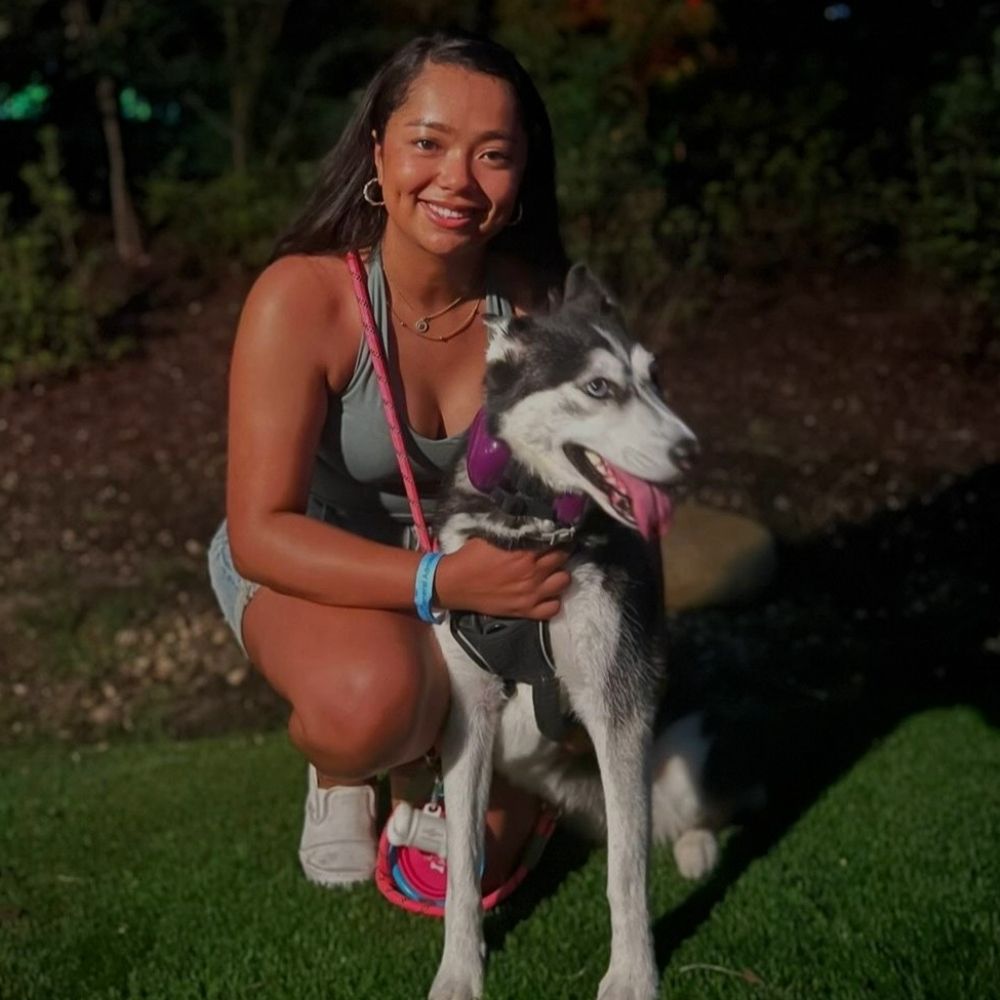 Barbara kneeling down and hugging her dog Athena
