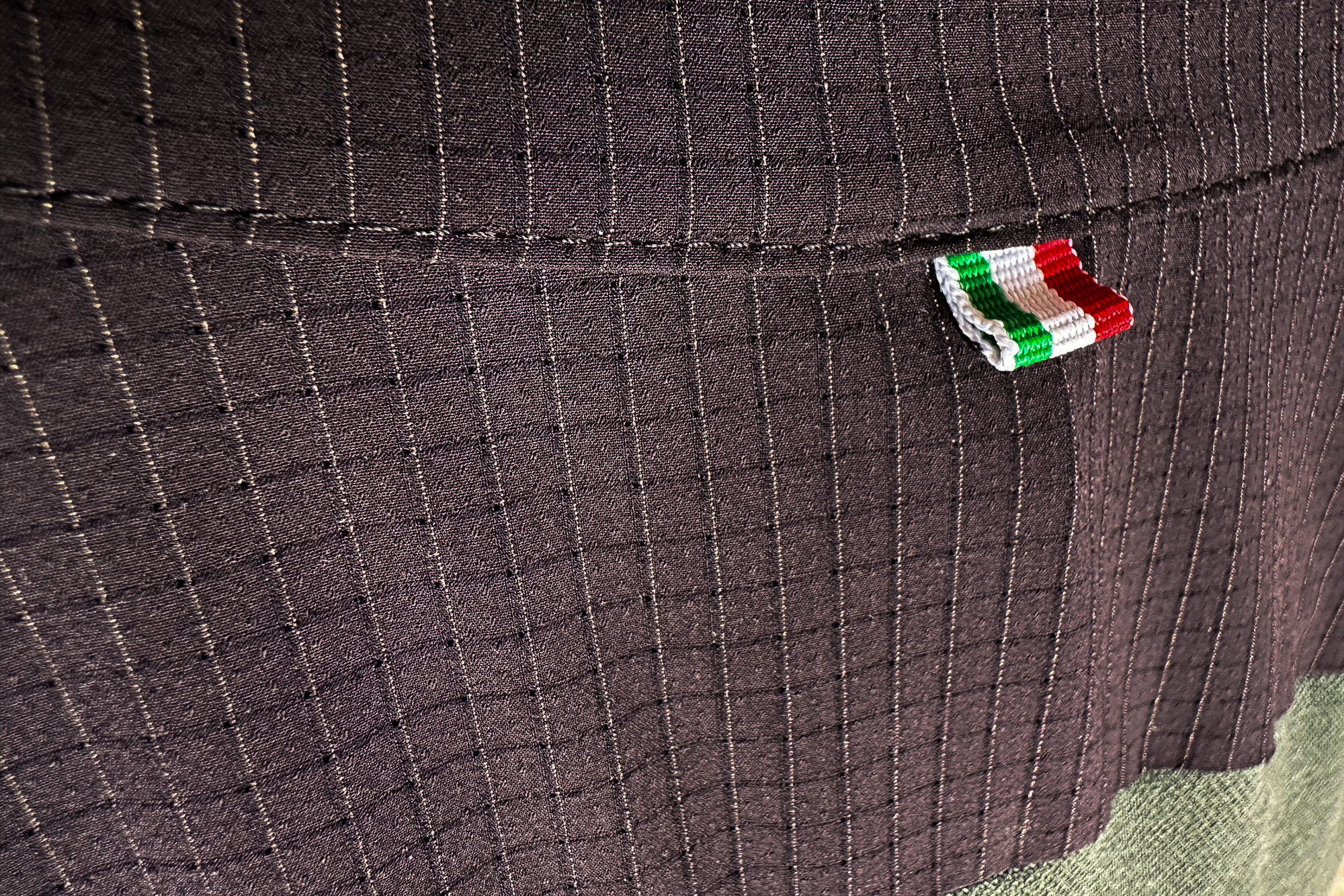 close up of the black grid material used on the shoulders and pockets of the jersey