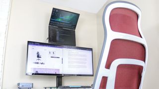 An office chair in front of a stacked monitor setup on a desk