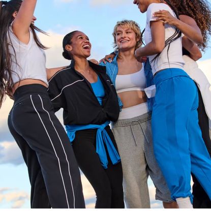 A group of women wearing Athleta activewear and cheering