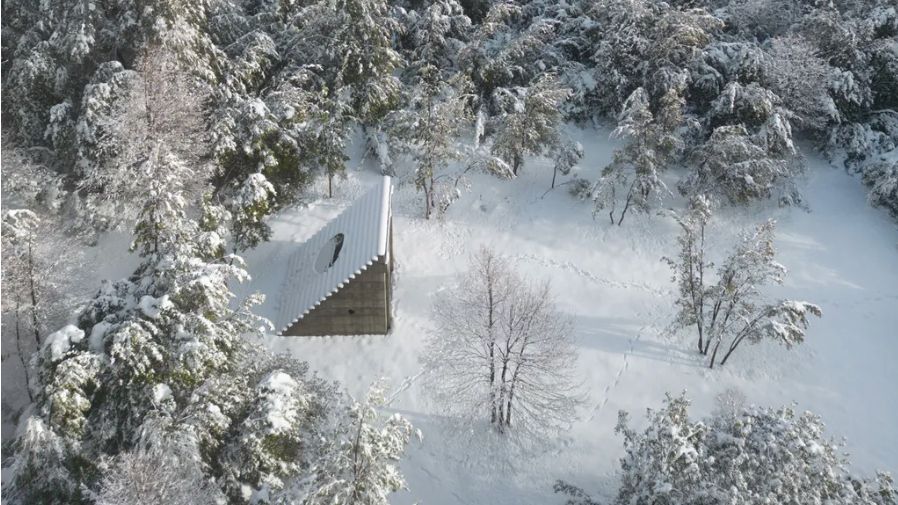 A Chilean pavilion cuts a small yet dramatic figure in a snowy, forested site