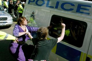 Two women shout abuse at a police van as Maxine Carr is transported from Peterborough Magistrates court August 21, 2002