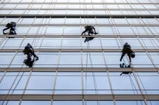 Window washers hanging from cables and ropes to clean office building in Charlotte, North Carolina 