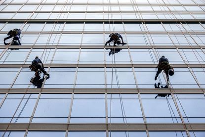 Window washers hanging from cables and ropes to clean office building in Charlotte, North Carolina 