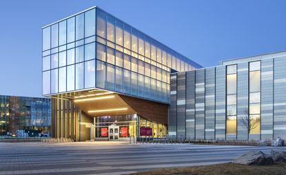 The Taylor Institute of Teaching and Learning at the University of Calgary. The photo was taken from the outside. We see the entrance and the rest of the building that's covered in panoramic windows.