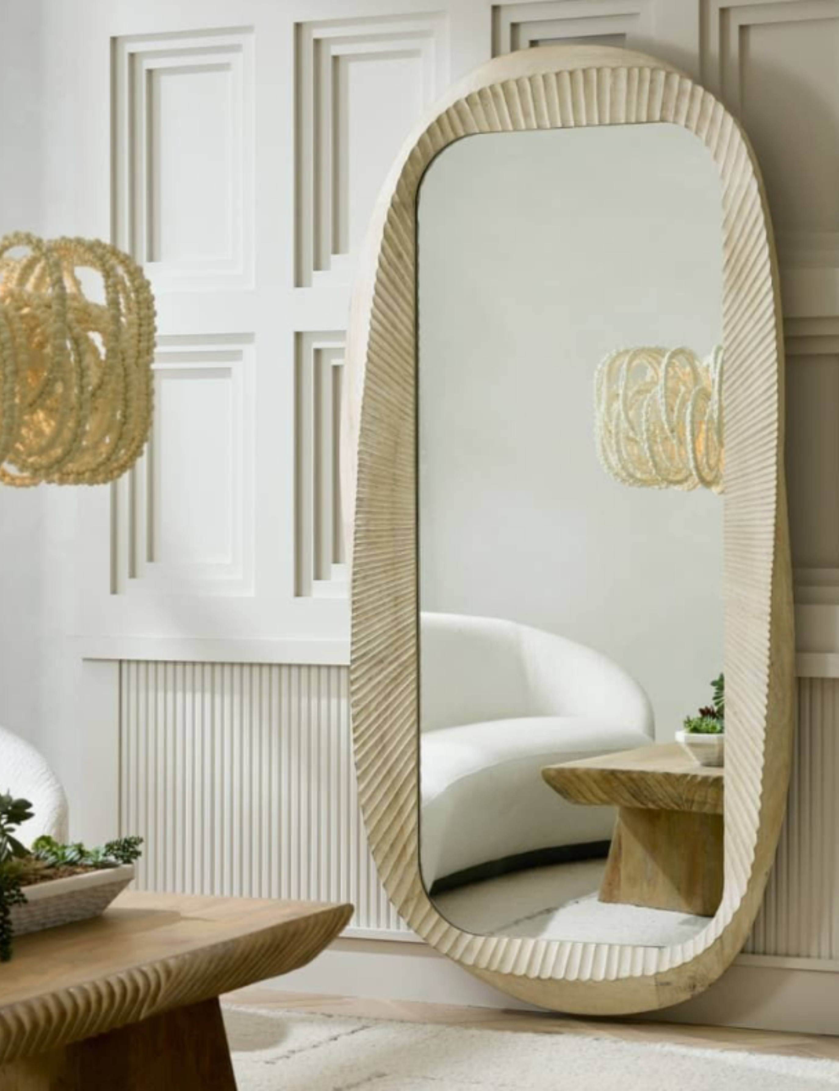 Arteriors floor mirror pictured in a neutral living room with ridged accents
