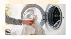 picture of woman loading the washing machine with laundry