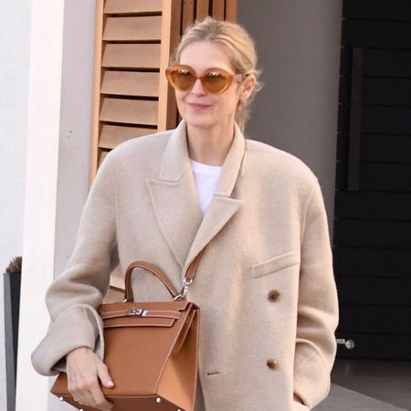 Kelly Rutherford wears beige loafers and a beige blazer.