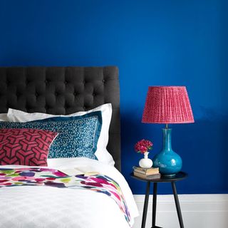 Bright blue bedroom with red and blue lamp