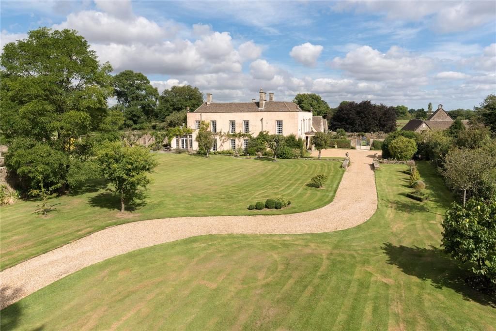 A shot of the home taken from afar showing the house and its gardens