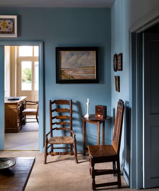 dark blue entryway with traditional wooden chairs and artwork