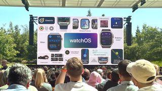 A view from the crowd's perspective from WWDC 2024 showing a giant screen with all of the new Apple Watch features coming to watchOS 11 summarized.