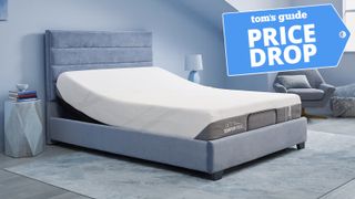 A Tempur-Pedic Tempur-Cloud Mattress on an Ease Power Base with the head of the bed lifted upwards, in a bedroom. A tom's Guide Price Drop deals graphic in the top right