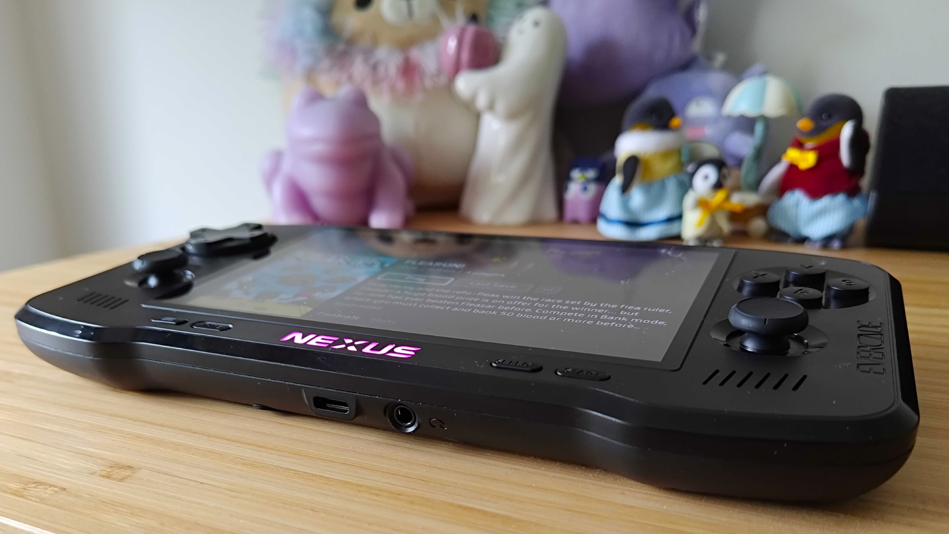 Angled bottom view of Evercade Nexus on light pine wood unit with purple illuminated logo.