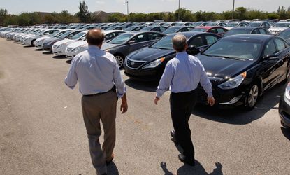 A car salesman helps a customer at a dealership in Florida.