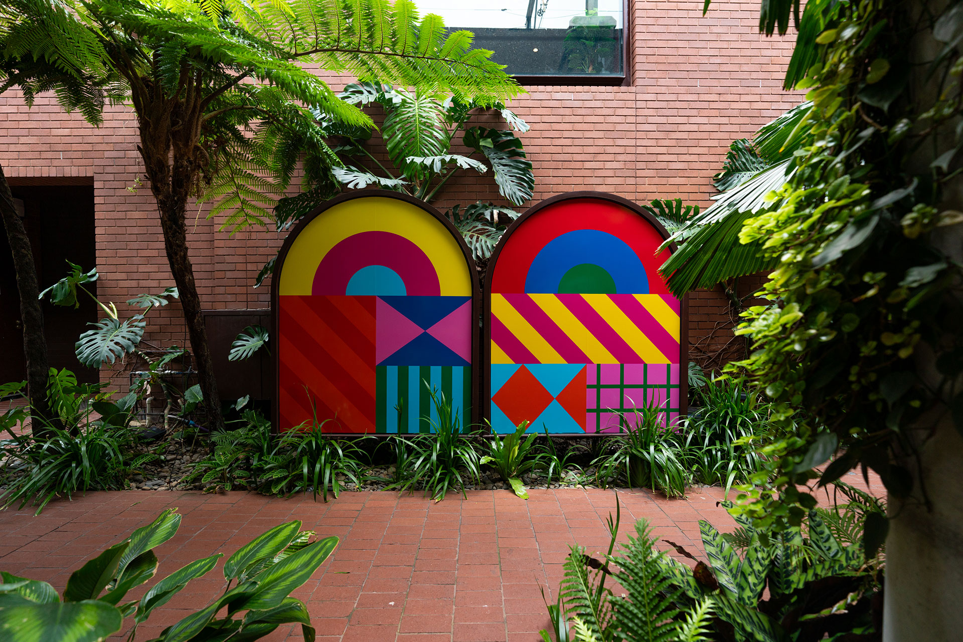Colourful geometric illustrations surrounded by plants