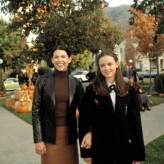 Scene from 'Gilmore Girls', mom and daughter on sidewalk with pumpkins in background