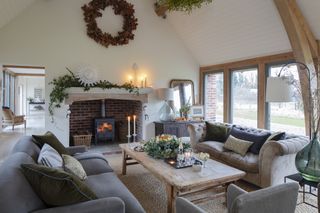 sitting room in oak frame house with fireplace and large windows