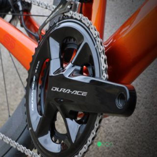 Chain ring and crank arm of an orange bike