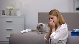woman sneezing allergic to her cat