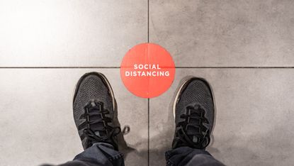 Standing at the social distancing marking sticker - stock photo
