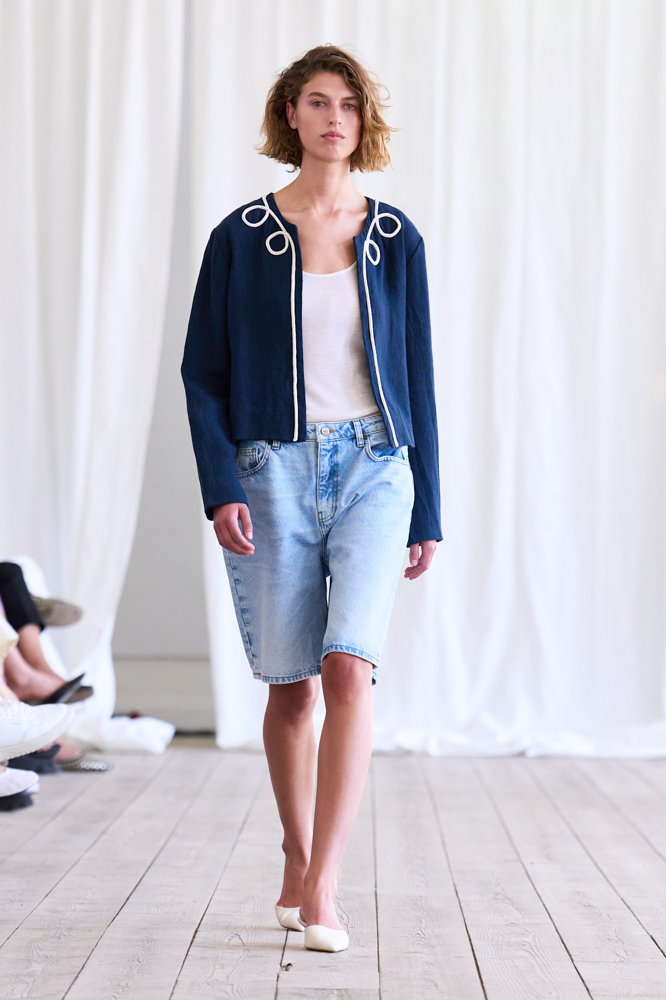 Woman in denim shorts, tank top and jacket
