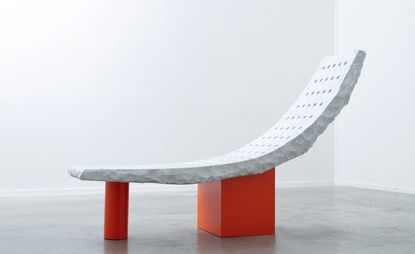 Bench with reclining marble seat and orange legs designed by Samuel Ross
