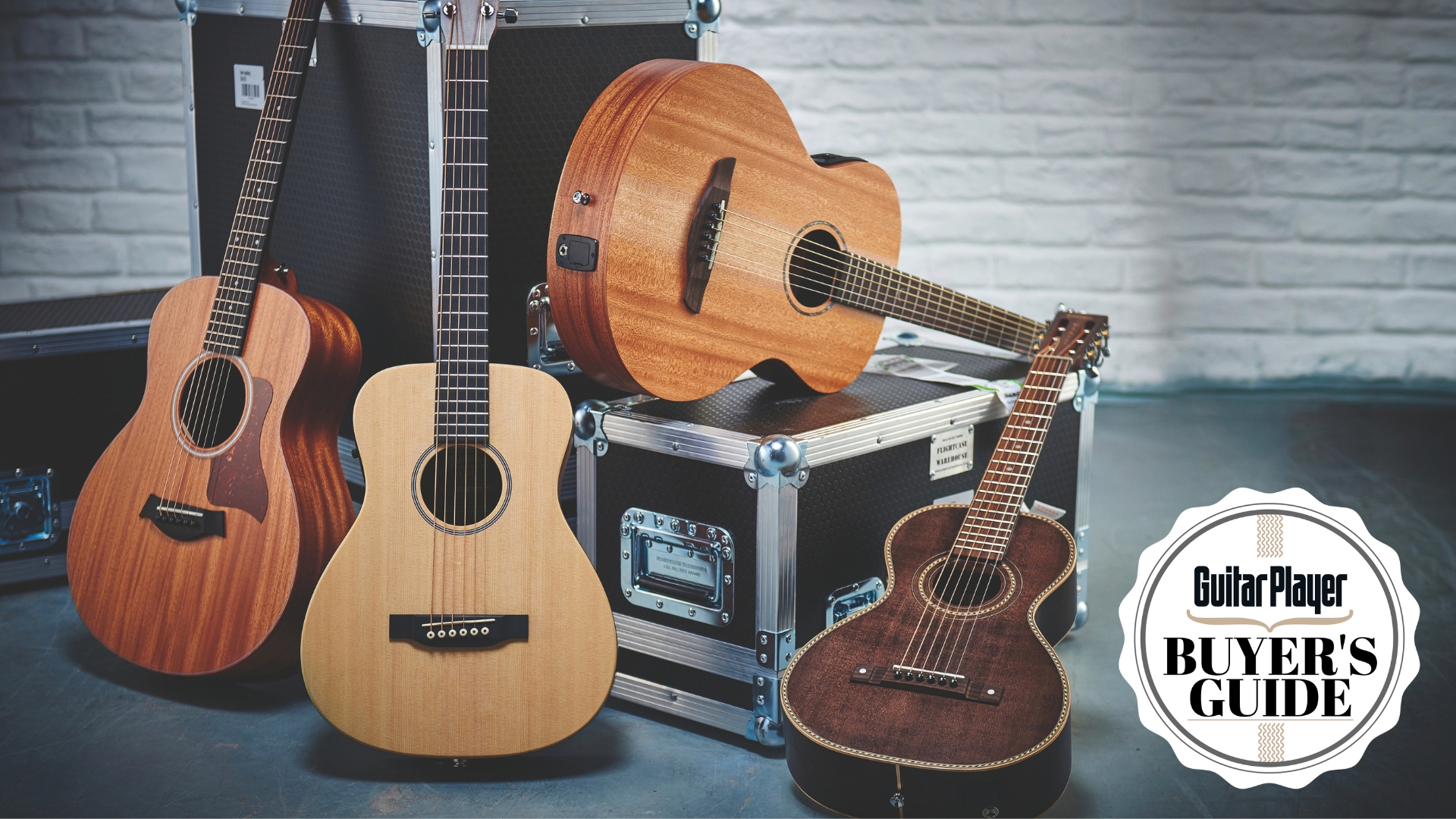 A selection of 3/4 acoustic guitars resting against and on top of flight cases