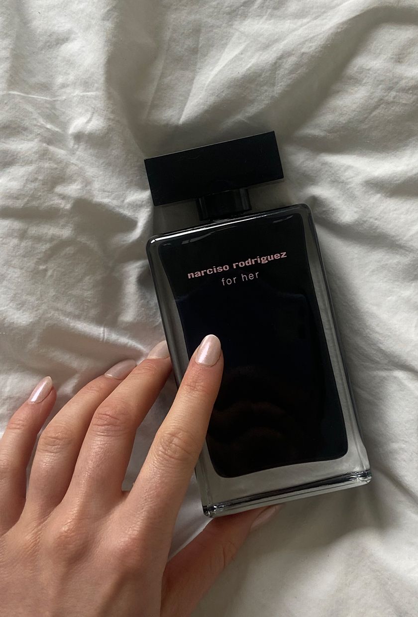 A bottle of Narciso Rodriguez For Her perfume bottle on a fabric background