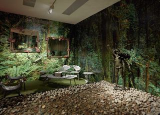 Tropical forest wallpaper, stone floor, seating area and sculpture