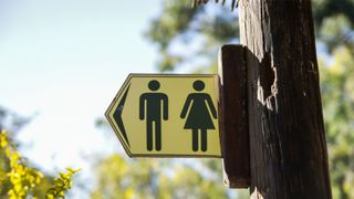 Public Restrooms sign for men and women on yellow background