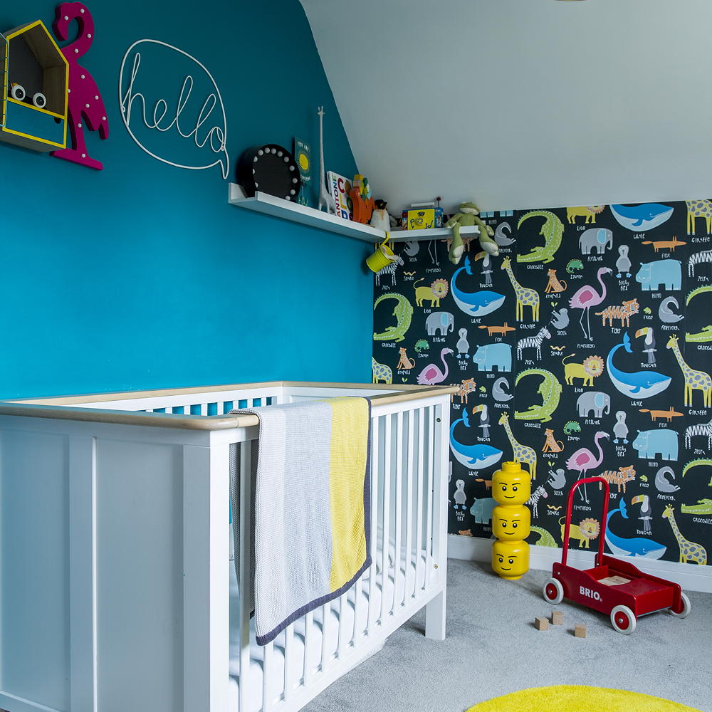 Nursery with turquoise wall and zoo animal wallpaper