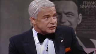 Phil Hartman's Frank Sinatra sits angrily on SNL.