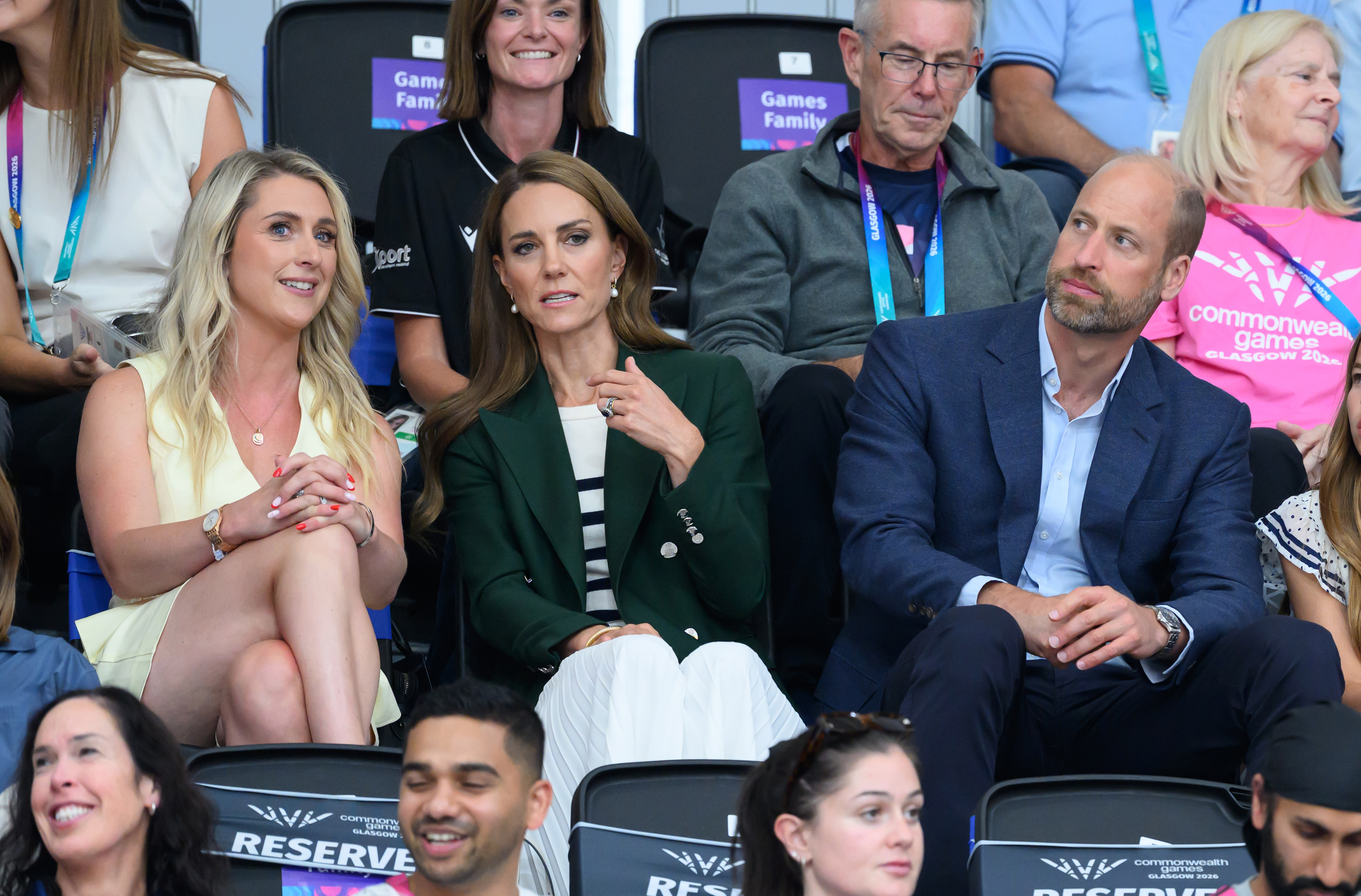 Princess Kate wears a green blazer a Breton striped top and Prince William has a bald head and wears a navy suit