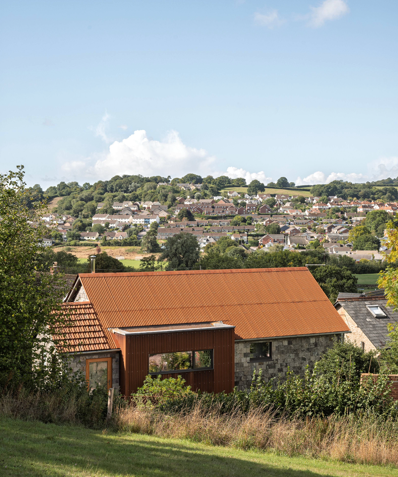 Exterior of the house with houses on the hills in the background
