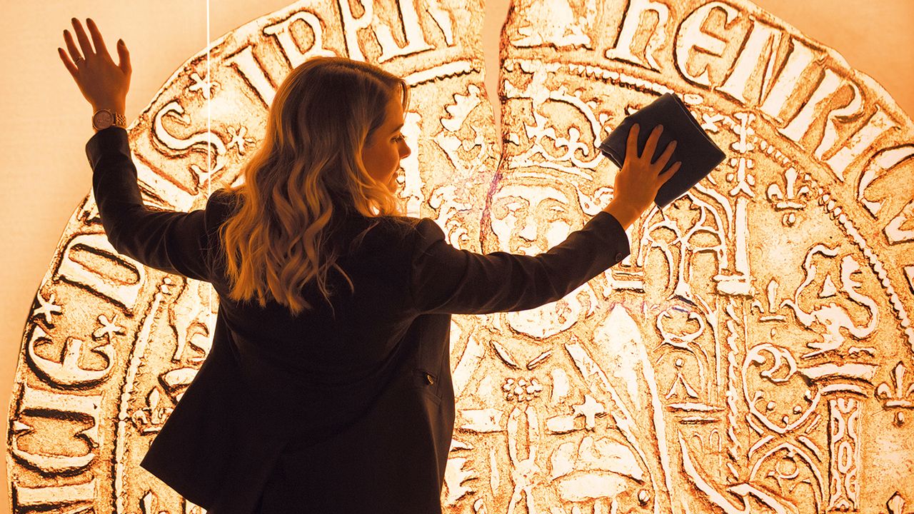 Woman cleaning a picture of a gold sovereign