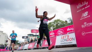A runner celebrates as she crosses the finish line of The Vitality Big Half on Sunday 22 August 2021