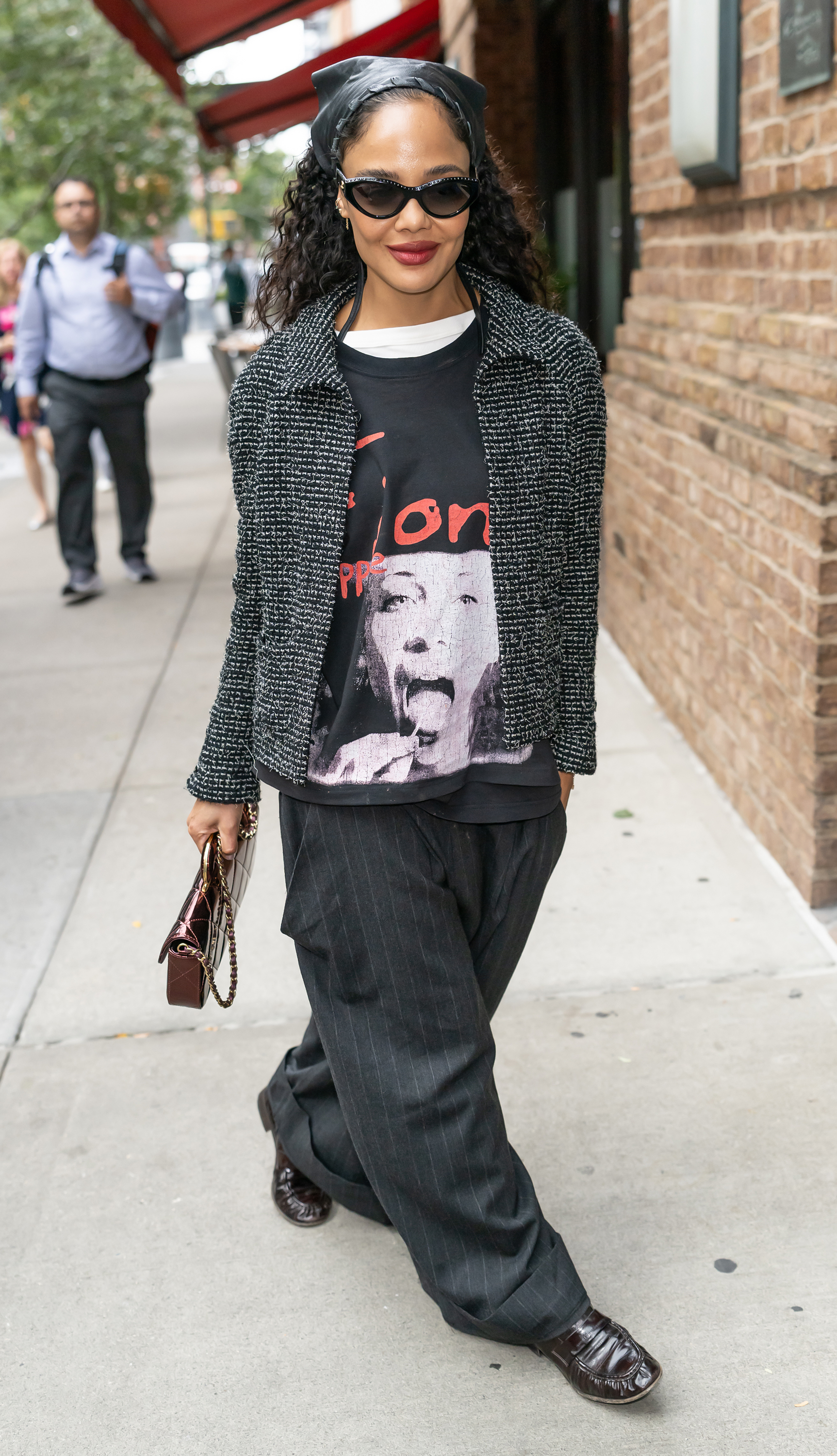 A woman wearing a leather bandana and oversized blazer