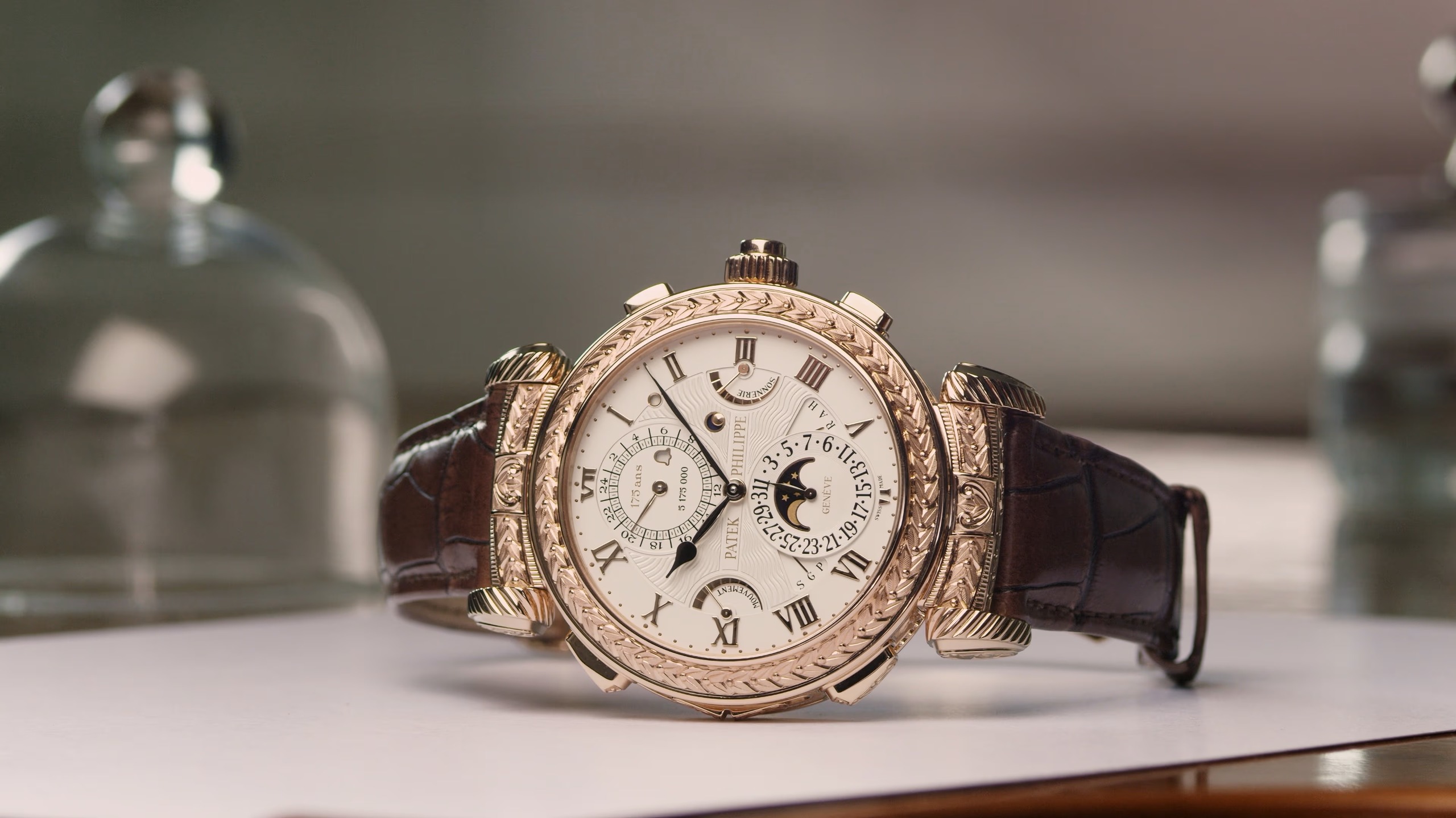 Wristwatch with a brown leather strap and ornate gold case 
