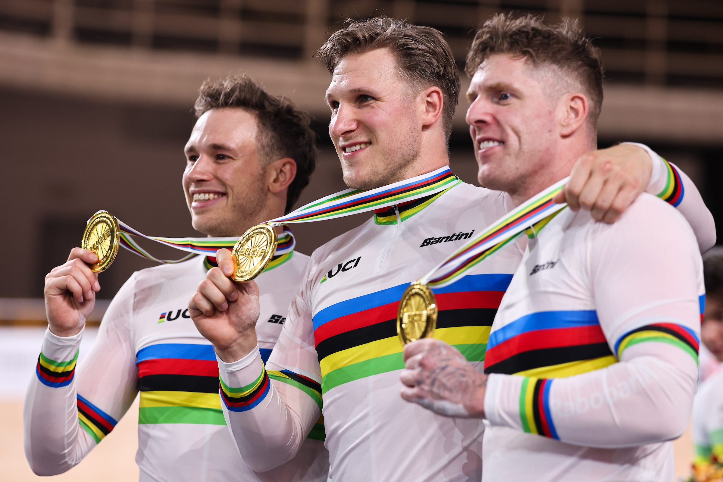Jeffrey Hoogland, Harrie Lavreysen, and Roy van den Berg (Netherlands) wearing the rainbow jersey as world champions, show their team sprint gold medals on the podium