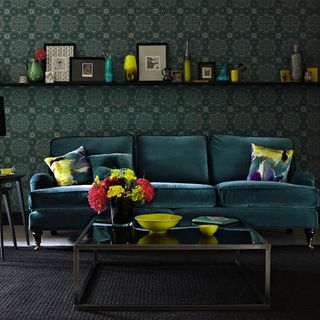 living room with green textured wallpaper and sofa set